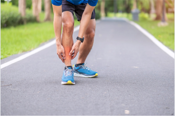 Runner with shin splints holding lower leg that is highlighted red demonstrating pain